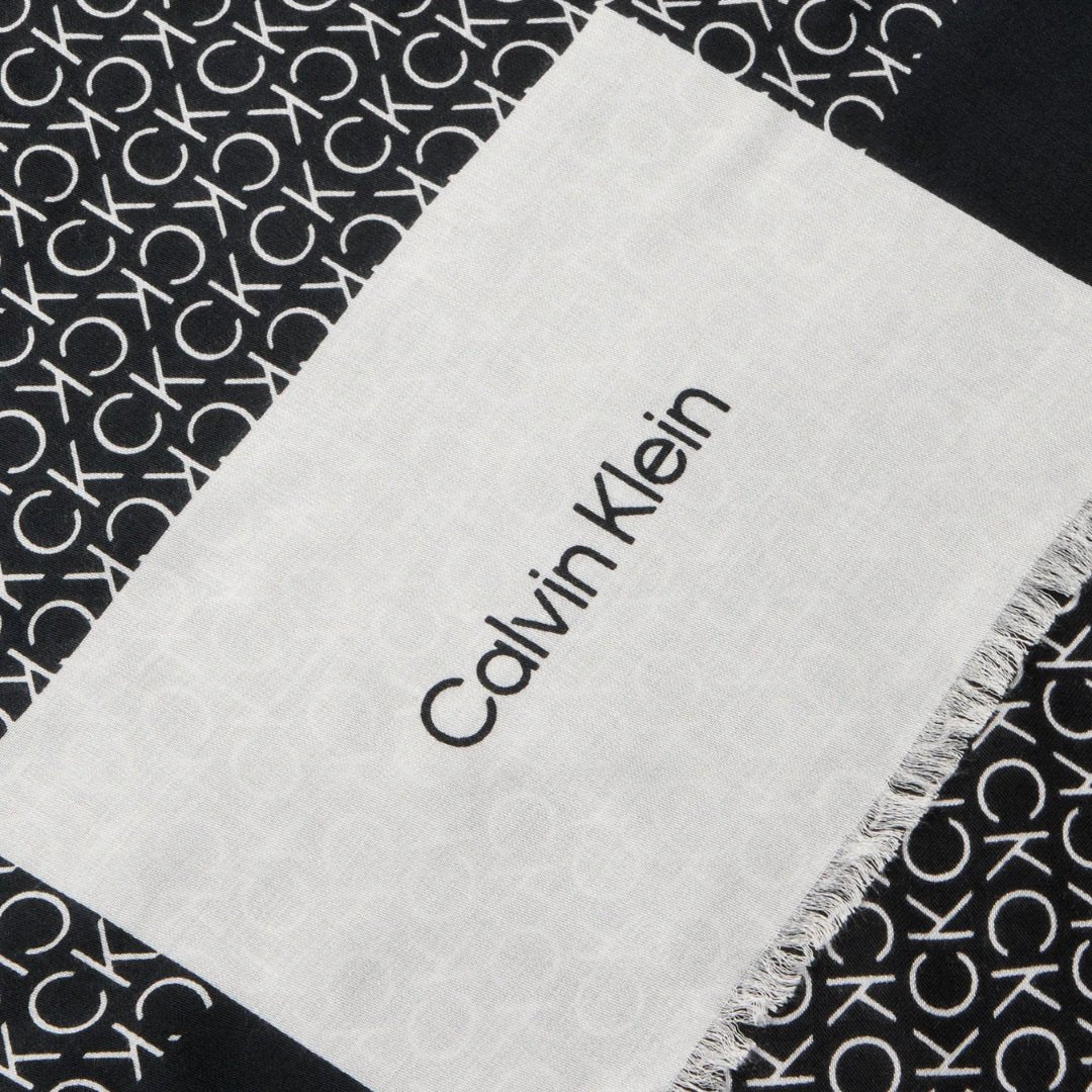 Écharpe Aop Minimal Logo Shwl 70 X de Calvin Klein, imprimé monogramme distinctif sur fond noir.