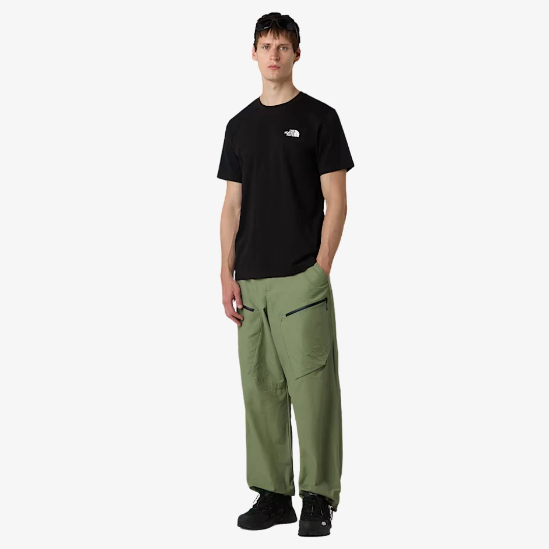Homme portant un T-shirt North Face confort quotidien avec un pantalon vert, vêtement décontracté et stylé.