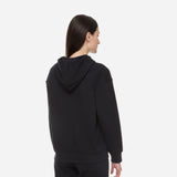 Woman wearing a black oversized pullover hoodie from New Balance, showcasing the back view and cozy design.