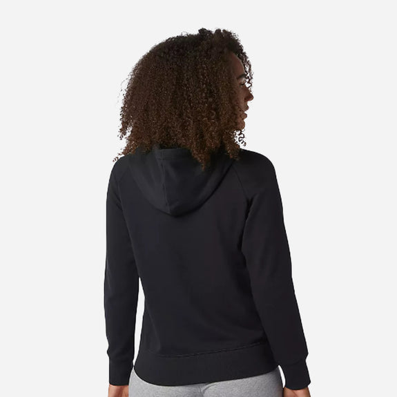 Woman wearing the New Balance Essentials pullover hoodie, showcasing the back design and comfortable fit.