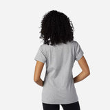 Woman wearing the New Balance Essentials Stacked Logo Tee from the back, showcasing a casual gray t-shirt style.