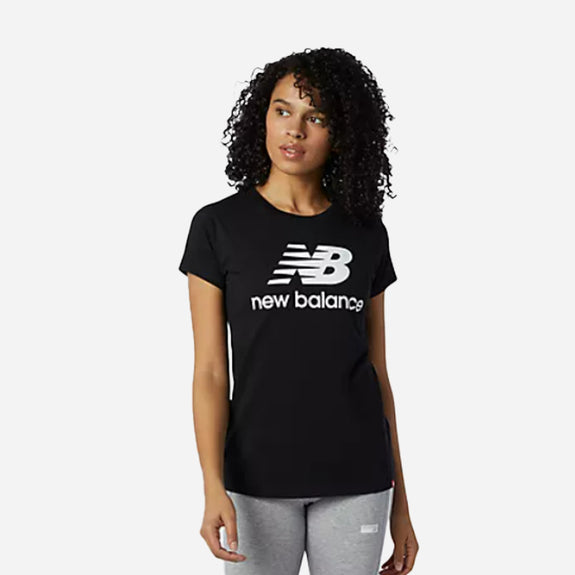 Woman in black New Balance Essentials Stacked Logo tee, showcasing a classic athletic style and soft cotton fabric.